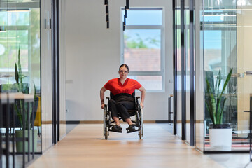 A modern young businesswoman in a wheelchair is surrounded by an inclusive workspace with...