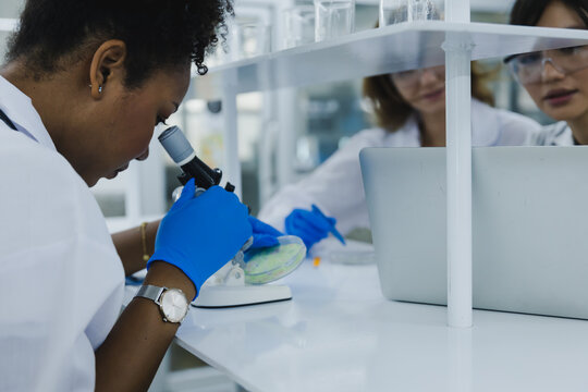 science technology chemist developing concept, female researcher, medical scientist or doctor or student is looking in a microscope in Modern Laboratory