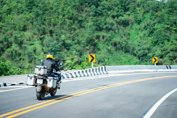 motorcycle on the road rides away. Travel on vacation, enjoy the nature trail. motorcycle in a sunny motorbike on the road riding.with sunset light. copyspace for your individual text. © PIPAT