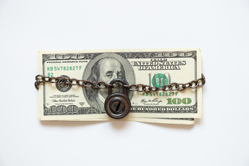 One hundred dollars on a chain under lock and key on a white background ,business