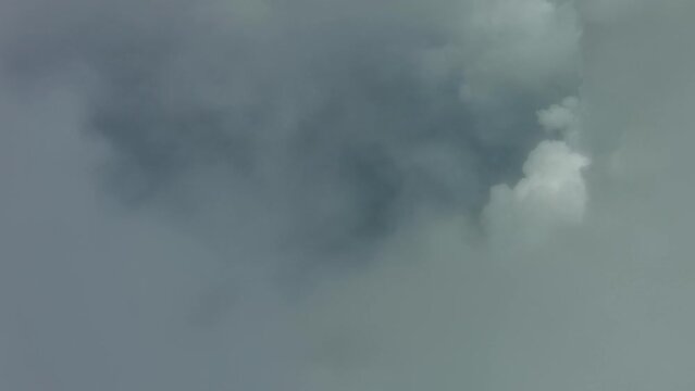 Flying through beautiful white fluffy clouds in blue sky. Airplane travel background, 4k