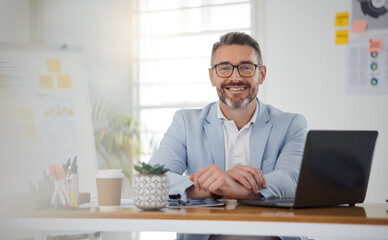 Fototapeta na wymiar Portrait of businessman at office desk with smile, laptop and tablet on business website, online report or social media. Internet, digital app and confident, mature man with workshop and web schedule
