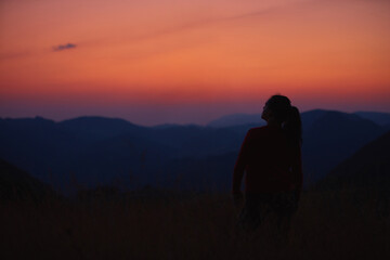 Fototapeta na wymiar Silhouette of a woman enjoying peacefully in nature.