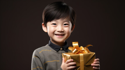 Happy smiling boy holding gift box on a colored background