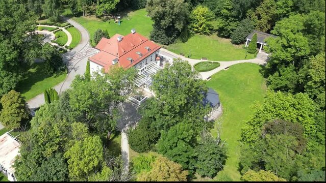 Aerial view of the historic palace in Tlokinia Kościelna, Poland. Admire the magnificent architecture and lush gardens of this property. Drone flight