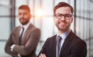 Fototapeta premium Portrait of two happy and confident business partners standing in a modern coworking center.