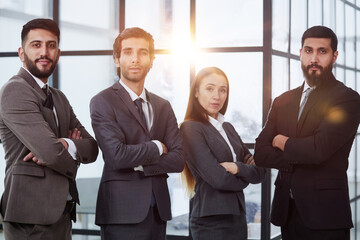 Portrait of four office workersr arms over their chest.