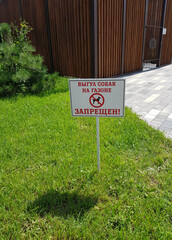 No dog walking sign on green grass background in summer in a modern residential complex. Animal care