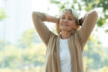 happy old woman breathe pure air from tree and have good healthy in park