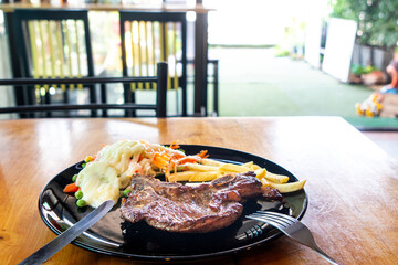 Pork chop steak on a black plate in a restaurant in Thailand
