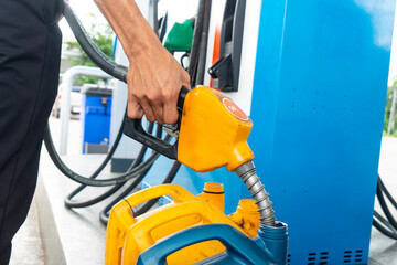 fuel station worker add oil to plastic gallon fuel container  at petrol filling station.