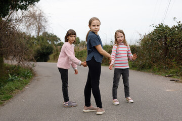 Obraz premium Funny children walking along the road in the village