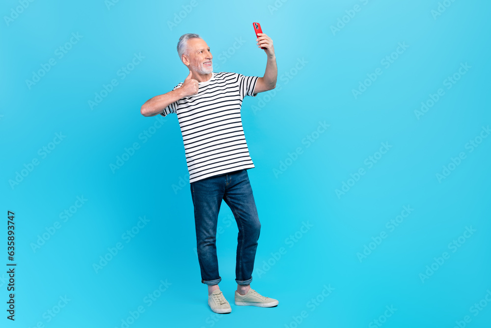 Poster Photo of positive white grey hair retired man wear stylish clothes look camera thumb up recommendation isolated on blue color background