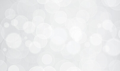 Abstract bokeh lights on light silver grey background. White bokeh glow sparkle banner background