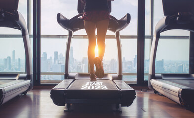 a happy new year 2023, 2023 represents the beginning of a new year. Sporty runner on treadmill at...