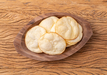 Smoked provolone cheese chips in a bowl over wooden table