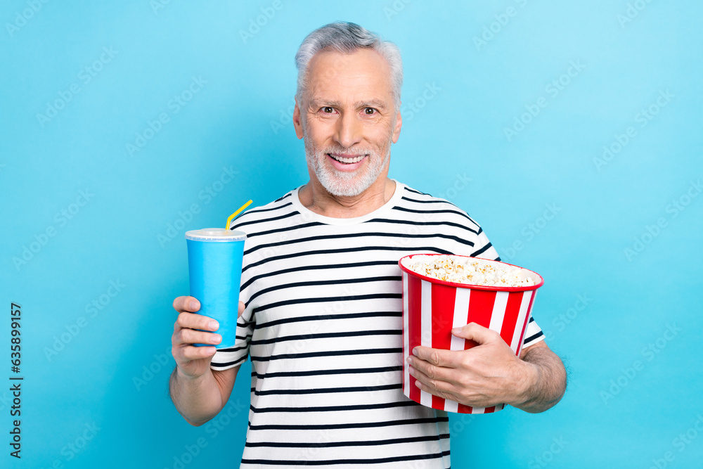 Poster Photo of excited cheerful man wear trendy clothes hold popcorn soda enjoy free time weekend isolated on blue color background