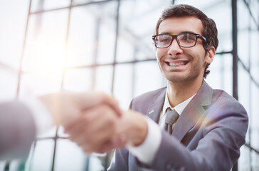 young businessman shaking hands with his partner