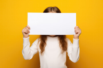 Girl pointing a blank white screen on a yellow background