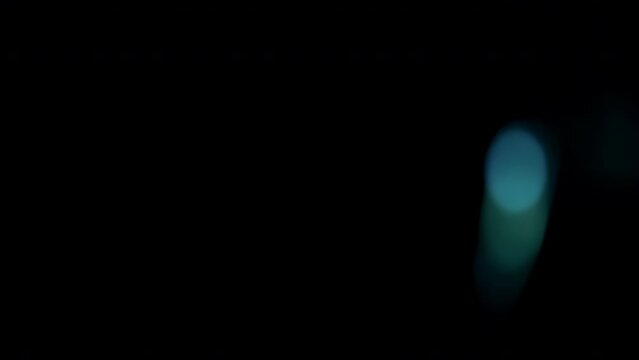 Real anamorphic lens flare from bright flash of light with blue leaks and bokeh, on right side of frame, video for effect of overlay and transitions.