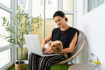 Adult Female CEO Working on Laptop with Yorkshire Terrier at Her Home. close-up