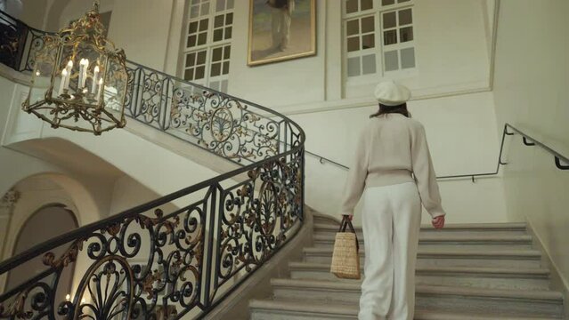 Beautiful girl climbing the ancient stairs in the Paris Museum in France