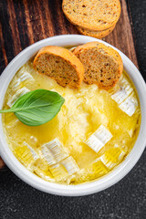 baked cheese camembert, brie or tartiflette soft cheese ready to eat healthy appetizer meal food snack on the table copy space food background rustic top view