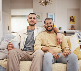 Happy, smile and portrait of a gay couple on a sofa relaxing with a cup of coffee in the living room. Love, bonding and young lgbtq men with a latte sitting together in the lounge at their home.