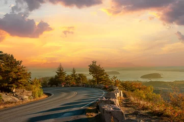 Road on the slopes of the mountains overlooking the bay of the Atlantic Ocean and the islands in the sunset light. Acadia National Park. USA