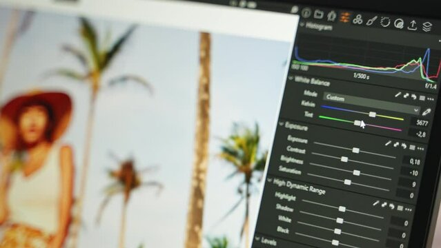 Photo editor working with image editing software. Travel photographer edits photos, adjusting exposure, white balance with sliders. Retoucher doing color correction for pictures on laptop screen.