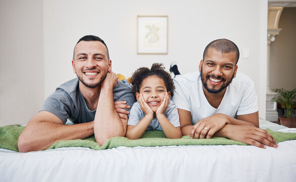 Gay, happy family and a child on a bed at home with love, care and safety in a bedroom. Lgbtq men, adoption and interracial parents with foster girl kid together in morning with a smile and happiness