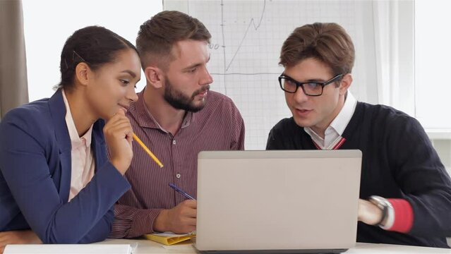 Creative team of two men and one woman sitting at the office