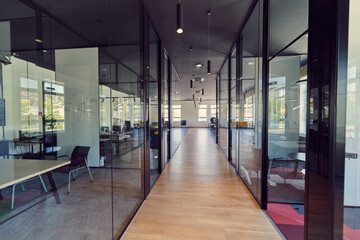 In a setting of modern, glass-walled business startup offices, the open, airy workspace reflects a...