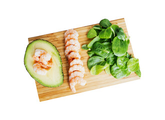 Avocado half, shrimps, basil leaves on wooden cutting board, top view flatlay, soft focus clipping...