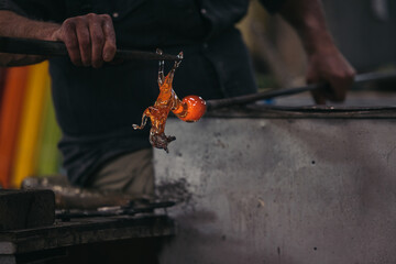 Unrecognizable craftsman with glassblower at workshop