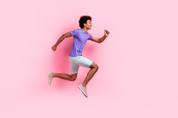 Fototapeta na wymiar Full length photo of positive excited funky man dressed blue t-shirt look running to empty space isolated on pink color background