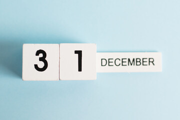 New Year, wooden calendar with the date December 31 on a blue background, flatlay