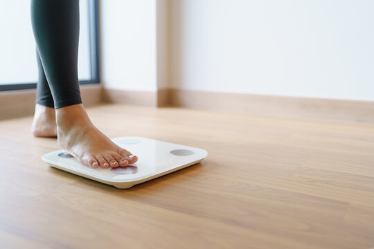 Lose weight. Fat diet and scale feet standing on electronic scales for weight control. Measurement instrument in kilogram for diet.