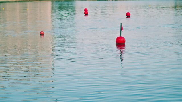 Red buoys on the lake with a flag