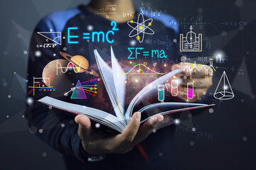 A student or physics scientist open a book to study theory of physics law of planetary gravitation motion and general relativity equation or light spectrum. Albert einstein and sir isaac newton laws