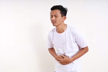 Asian adult man having stomachache. Isolated on white background with copyspace