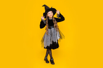 Happy smiling baby on Halloween. A full-length schoolgirl in a carnival witch costume. A young girl...
