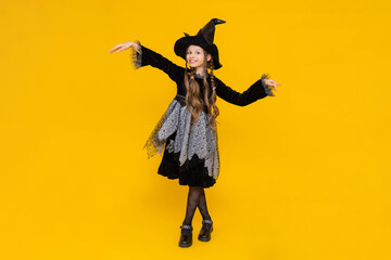 Happy smiling baby on Halloween. A full-length schoolgirl in a carnival witch costume.  Seasonal...