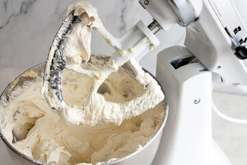 Mixed Vanilla Buttercream Icing in a Stand Mixer: Mixed frosting in a stand mixer fitted with a paddle attachment