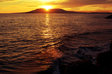 Beautiful sunset on the sea. Golden hour in the city of Malaga, Spain. Mountains, sun, sea, ship. Spanish resort