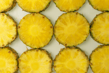 Pineapple juicy yellow slices on a white background.
