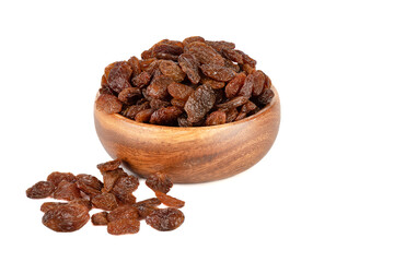 Dehydrated sweet raisins in a wooden bowl and on a white background.