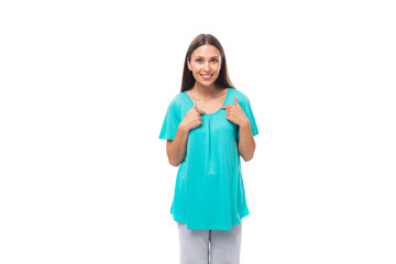 portrait of a pretty young caucasian brunette woman with long hair in a blue t-shirt on a white background with copy space