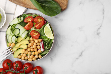 Tasty salad with chickpeas and vegetables served on white marble table, flat lay. Space for text