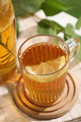 Glass cup of tasty iced tea with lemon on table, closeup